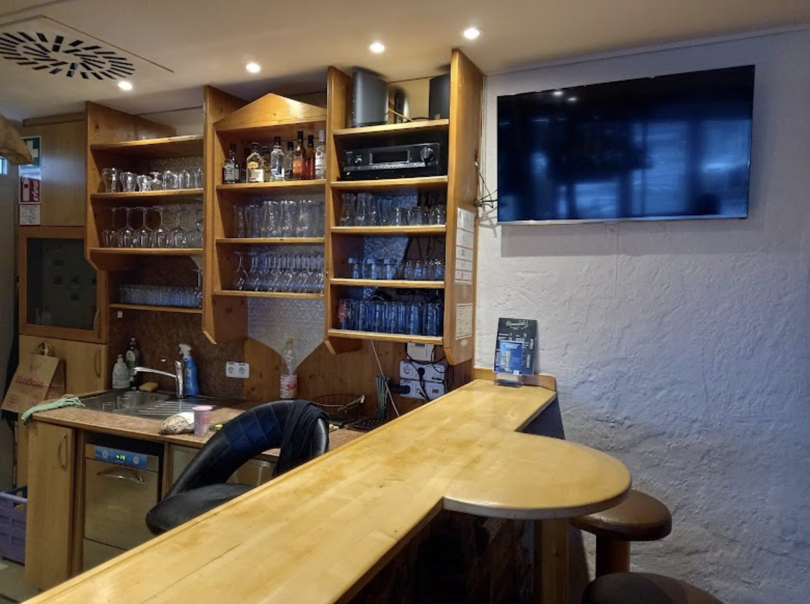 Bar mit Gläserregal und Fernseher