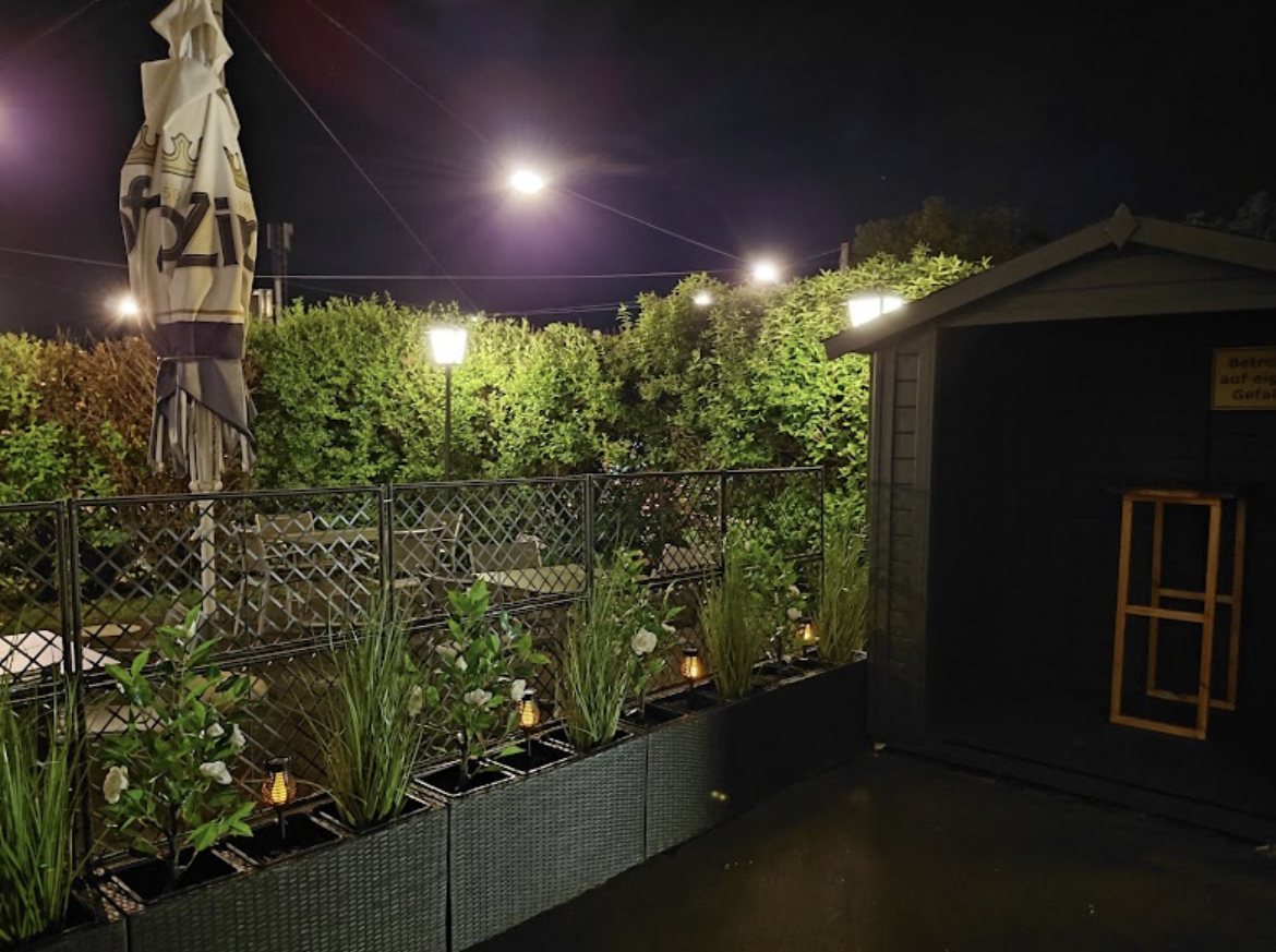 Gastgarten bei Nacht mit Lichterketten